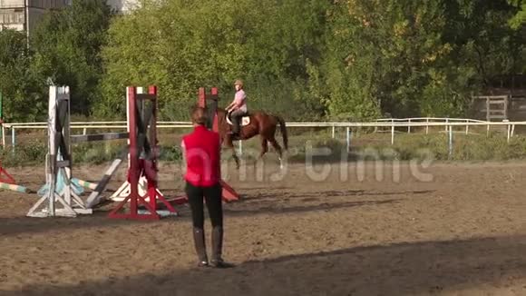 与教练一起骑马的少女视频的预览图