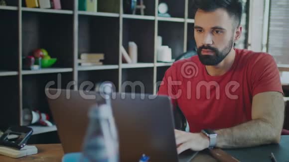 年轻的商人在家庭办公室用笔记本电脑工作现代经理视频的预览图