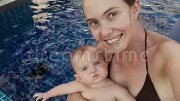 年轻快乐的妈妈带着孩子去游泳池视频的预览图