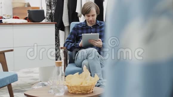 幸福的男企业家用数码平板电脑在她的现代商店里和女人衣服做半长画像视频的预览图