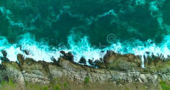 海潮海浪正在冲刷岩石海岸上的大岩石视频的预览图
