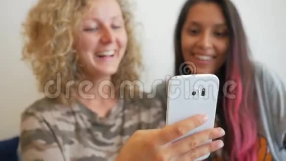 两个迷人的混血模特坐在咖啡馆里用手机看有趣的视频生活方式高清慢动视频的预览图