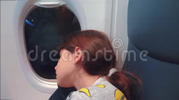 航空飞机概念坐在窗边的小女孩睡在飞机上晚上乘飞机视频的预览图