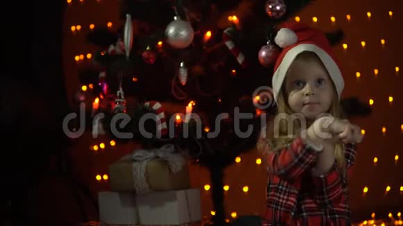 小女孩打开装饰圣诞树下的礼盒视频的预览图