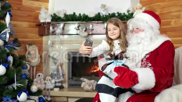 小女孩与圣诞老人和她的礼物自拍孩子访问圣诞老人住所圣诞节视频的预览图