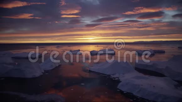 格陵兰冰峡带冰山的景观午夜太阳日落日出在地平线上空中无人机镜头视频的预览图