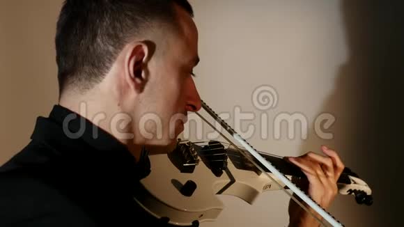 在暗室里拉小提琴的年轻人视频的预览图