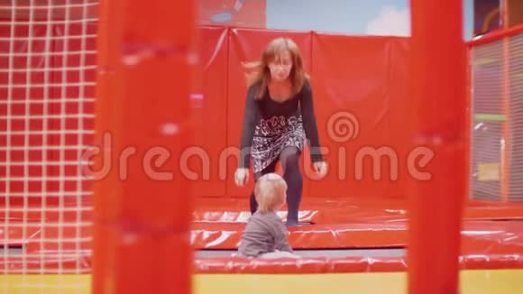 妈妈和蹒跚学步的儿子玩蹦床视频的预览图