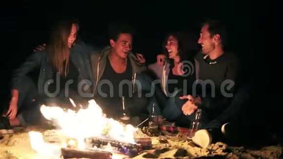 不同的人群在深夜坐在炉火旁互相拥抱快乐的朋友视频的预览图