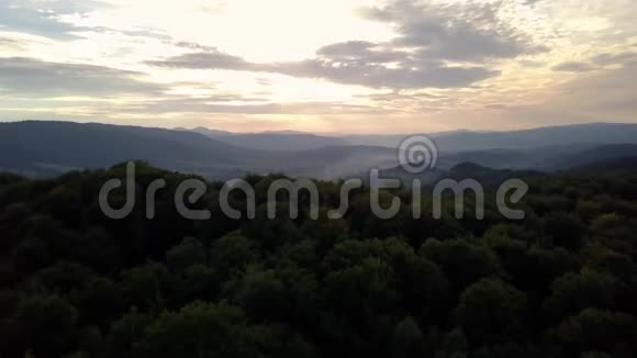 空中无人机镜头取景在日出柔和的光线下飞越秋天的山村森林田野和河流视频的预览图