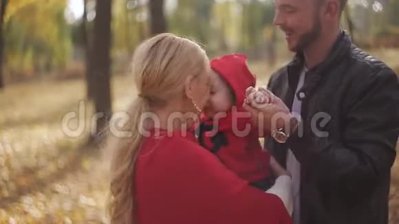快乐的爸爸妈妈在秋天公园和她的孩子玩耍视频的预览图