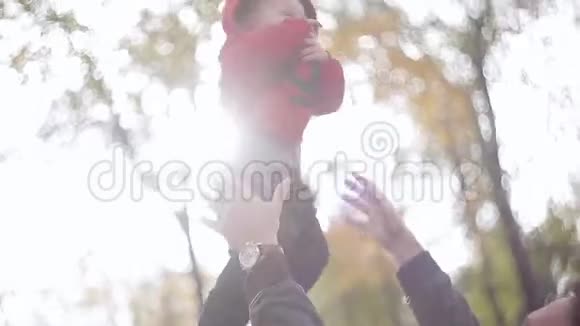 爸爸在一个秋天的公园里扔东西抓住一个小儿子视频的预览图