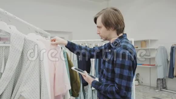 幸福的男企业家用数码平板电脑在她的现代商店里和女人衣服做半长画像视频的预览图