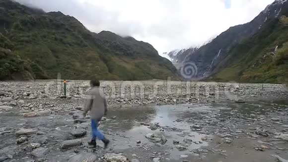 在新西兰福克斯冰川小径漫步的女游客视频的预览图
