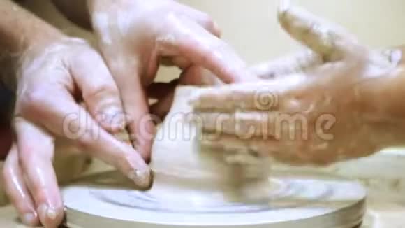 成人和儿童制作泥壶的手视频的预览图