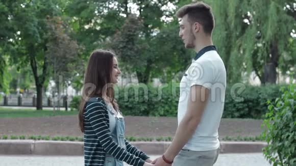 爱的年轻夫妇牵着手在公园里聊天视频的预览图