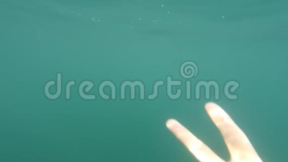 男性手显示胜利手势标志在蓝色水下背景与气泡和阳光手势和手势视频的预览图