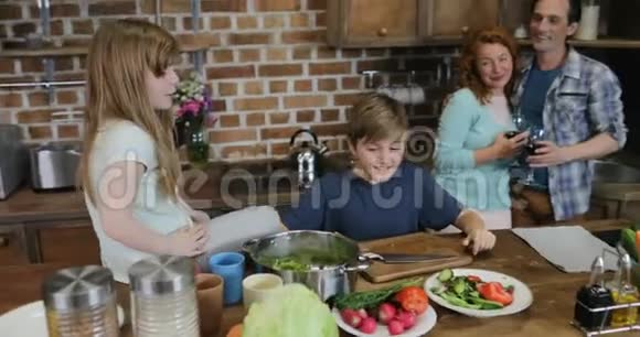 孩子们帮助父母做饭幸福的家庭一起在厨房准备食物视频的预览图
