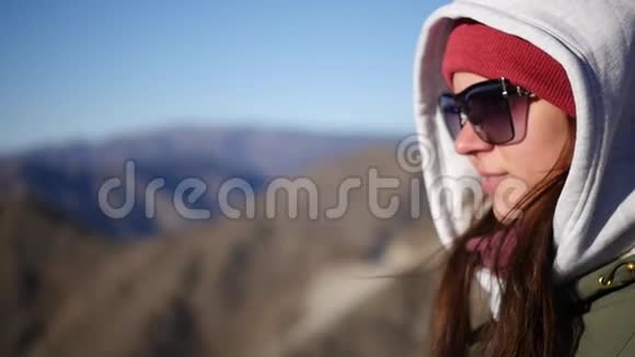 一个戴着黑色太阳镜和头巾的女孩站在山顶上欣赏风景慢动作1920x1080满视频的预览图