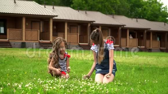 两个姐妹坐在草坪上在公园里休息视频的预览图
