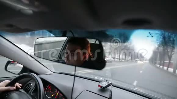 严肃的人他的脸在汽车的镜子里视频的预览图