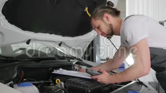 男机修工检查流动汽车写服务书视频的预览图