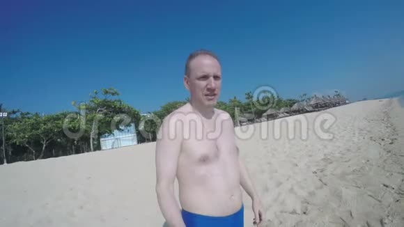 这个人在海滩上长着一张严肃的脸在海里奔跑落水和游泳视频的预览图