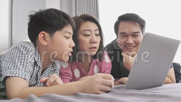 家庭幸福爸爸妈妈和儿子坐在笔记本电脑上玩得开心视频的预览图