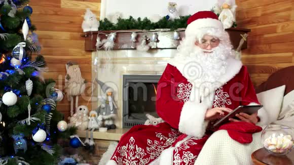 圣诞老人使用平板电脑圣尼古拉斯使用平板电脑上网数字设备圣诞节视频的预览图