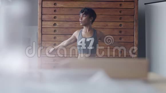 年轻健康的女人在阳光明媚的阁楼里做伸展运动视频的预览图