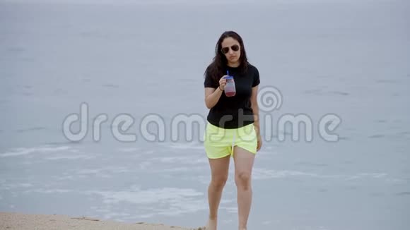 美丽的女孩走在海边的沙滩上视频的预览图