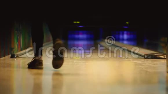 在保龄球比赛俱乐部里运动员投掷一个保龄球击倒滑球焦点的平稳移动视频的预览图
