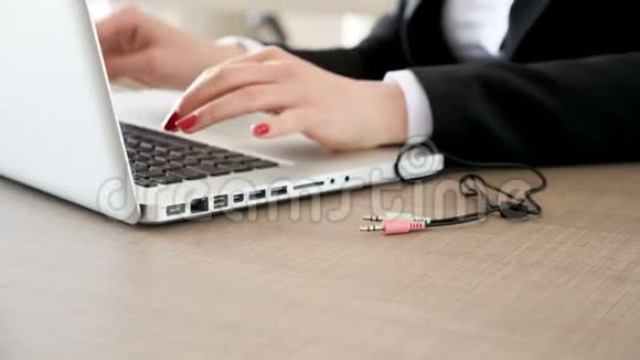 女人在笔记本电脑上打字然后把电线插在电脑上视频的预览图