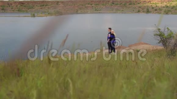 女孩拥抱她的丈夫在美丽的湖边视频的预览图