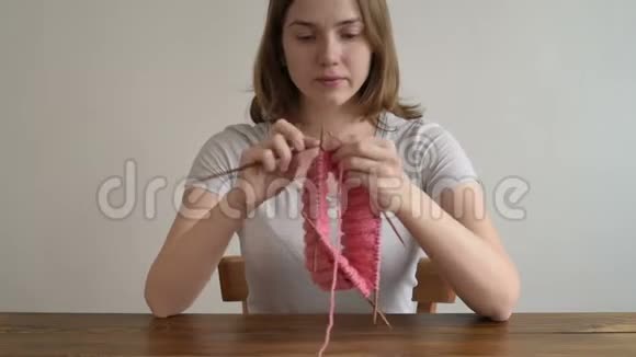 可爱的女人编织一顶粉红色的帽子视频的预览图