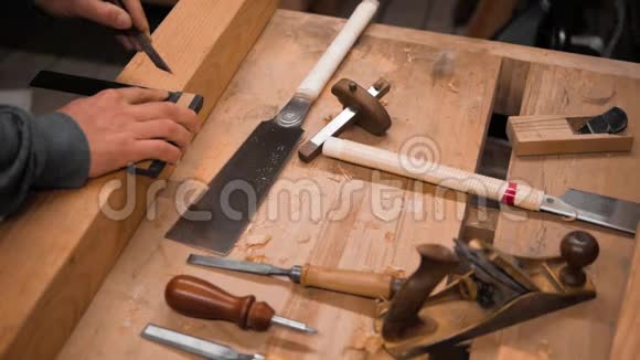 木匠用正方形和刻痕刀对工件进行标记视频的预览图