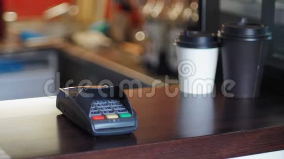 咖啡馆里的女商人用智能手表和终端机来支付价格视频的预览图