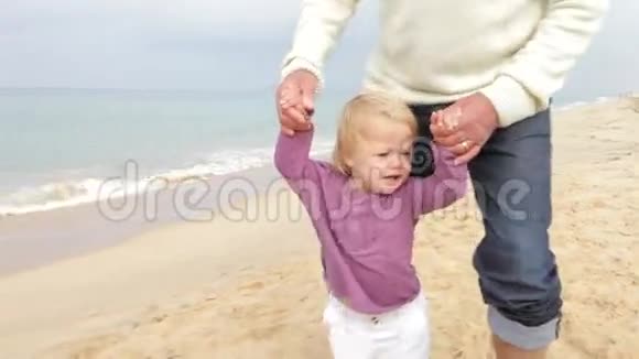 祖父母和孙女一起沿着海滩散步视频的预览图