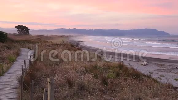 在怀希海滩上空粉红色的日落天空视频的预览图
