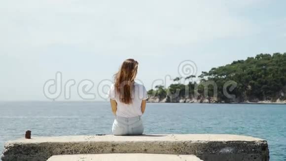 坐在码头边上的女人在湖边放松视频的预览图