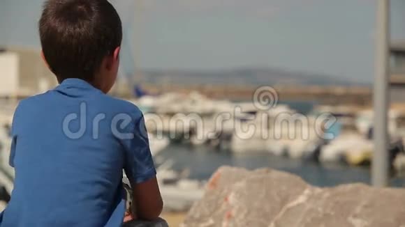 男孩看着海上的游艇视频的预览图