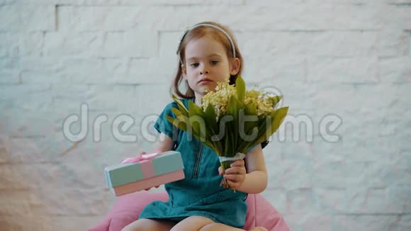 可爱的女孩展示鲜花和礼物并送上亲吻视频的预览图