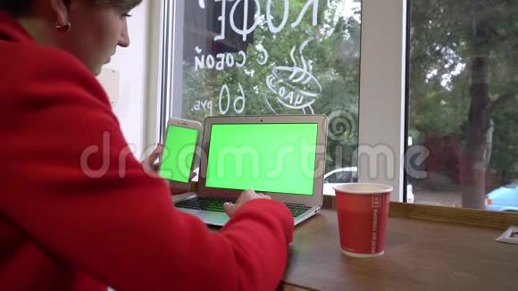 咖啡店里的商务女孩用笔记本电脑和电话工作视频的预览图