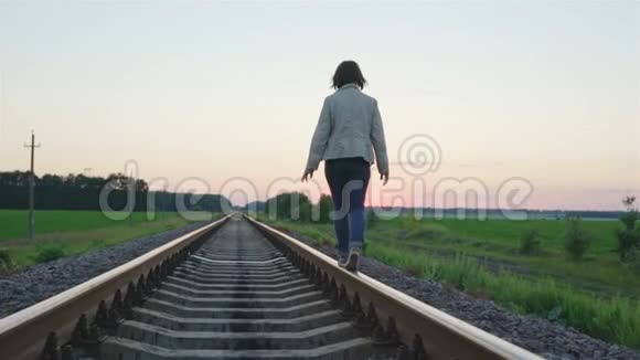 女孩走在铁路轨道上视频的预览图