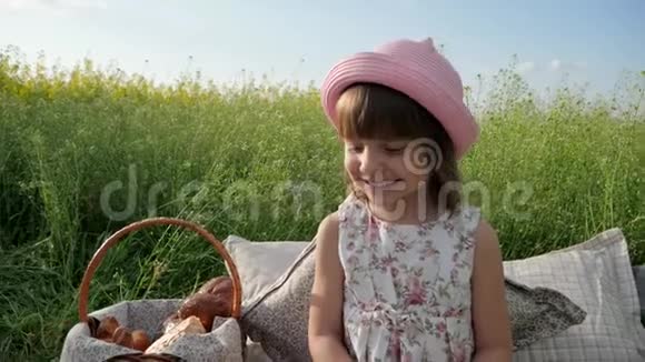 儿童野餐性质可爱的小女孩肖像吃百吉饼面团产品在日落时喝牛奶孩子在家庭野餐视频的预览图