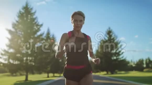 女子跑步者慢动作女运动员在公园路上奔跑视频的预览图