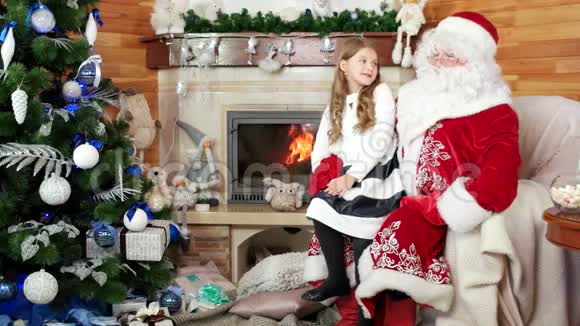 女孩坐在圣塔普快乐的孩子告诉诺埃尔爸爸他的圣诞愿望微笑的年轻女士视频的预览图
