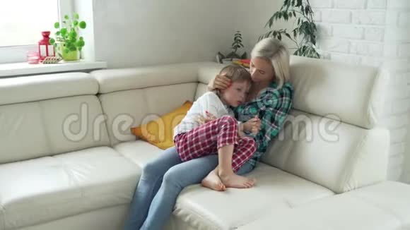 母亲在后台测量生病孩子的体温病儿高烧躺在家里的沙发上视频的预览图