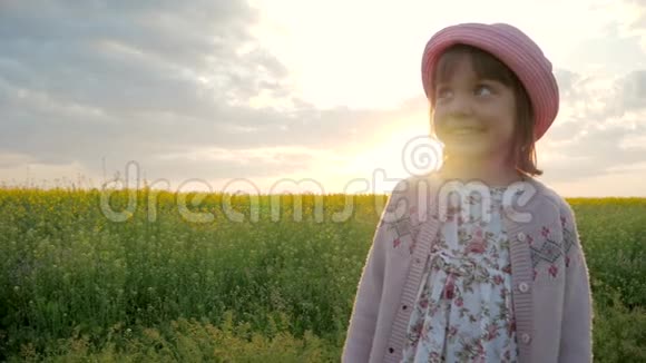肖像微笑的女孩快乐的孩子背景花田女孩子在巴拿马帽子在头上孩子看着视频的预览图