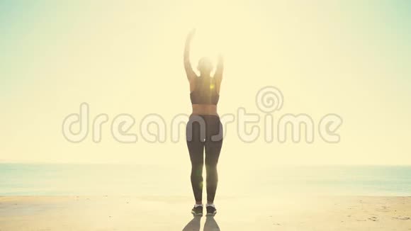 美丽的运动女孩在海边日出训练视频的预览图
